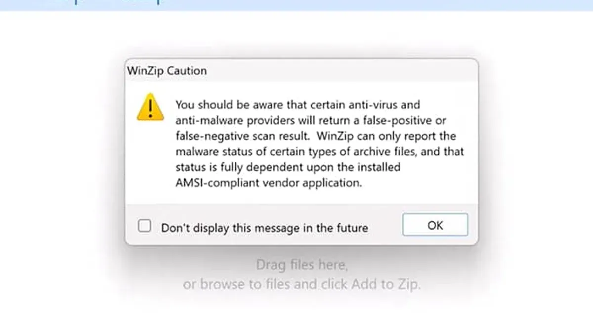 Person viewing a laptop screen with a warning about virus risk from a ZIP file