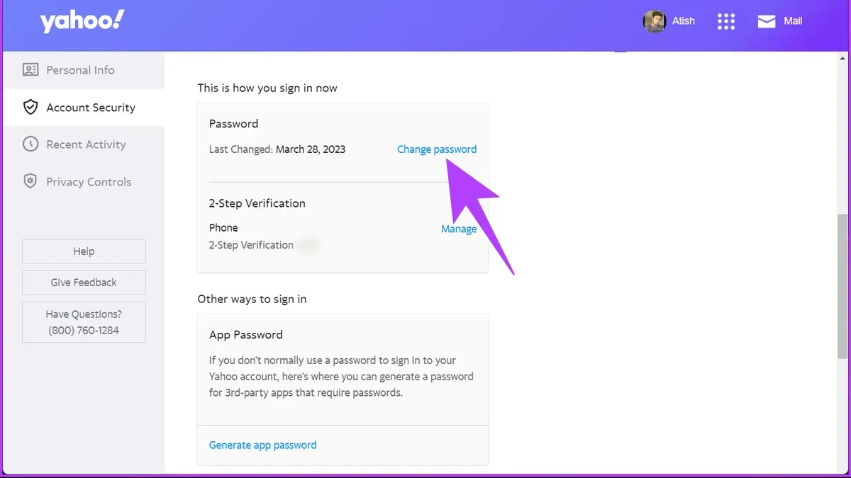 User changing Yahoo Mail password on smartphone with laptop open nearby