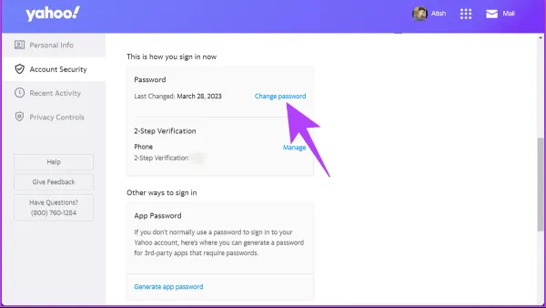 User changing Yahoo Mail password on smartphone with laptop open nearby
