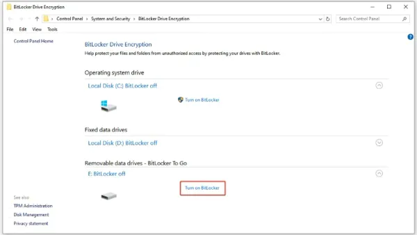 Person encrypting an external hard drive using a laptop showing encryption software